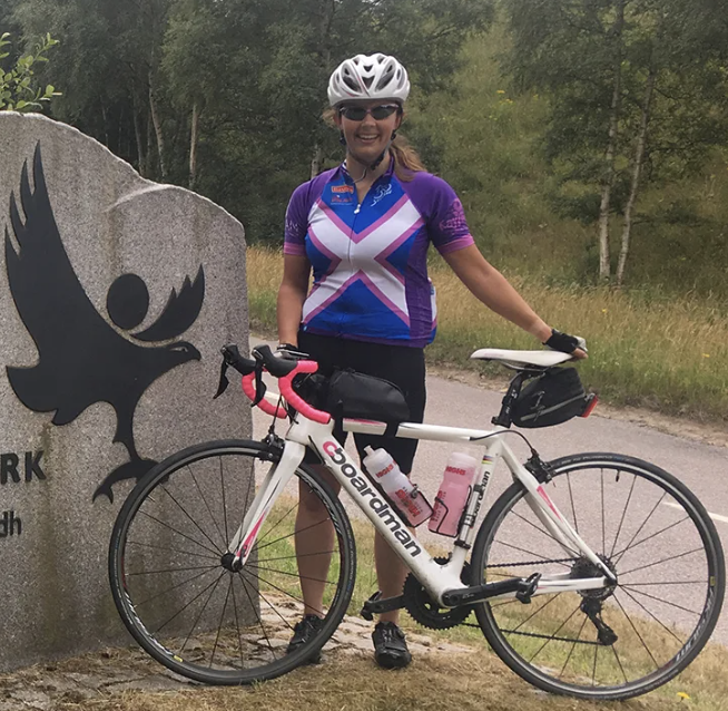 Woman road cycling in Scotland Countryside