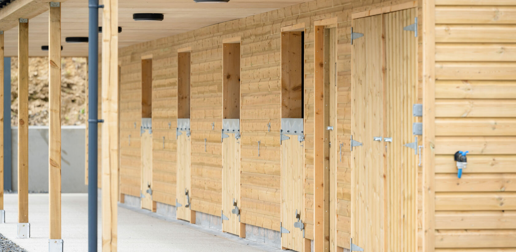 A row of wooden stable doors in a barn-like structure.